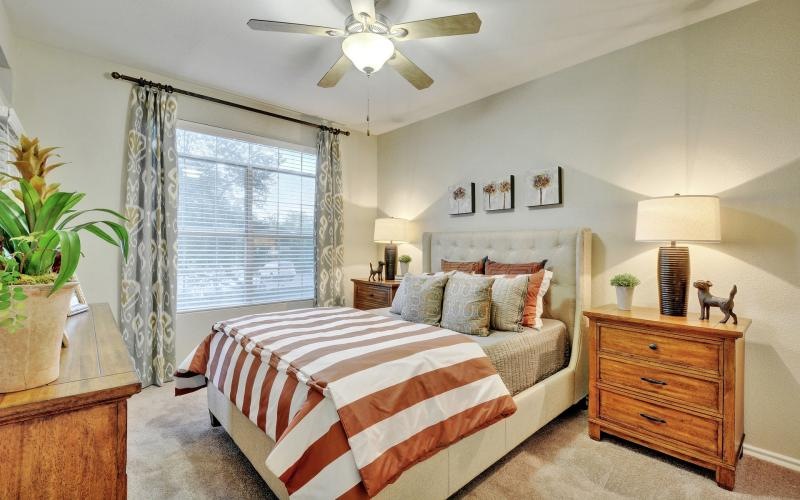 a bedroom with a fan and a bed