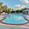a swimming pool with lounge seating next to a building